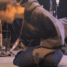 a person kneeling down with a guitar strap with stars on it