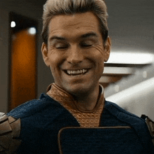 a man in a superhero costume is smiling with his eyes closed and his mouth open .