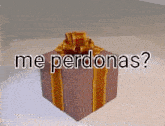 a gift box with a bow on it and the words `` me perdonas '' written on it .