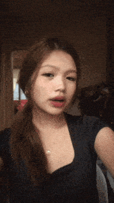 a woman in a black shirt is taking a picture of herself