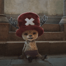 a stuffed animal wearing a red hat with a white cross on it