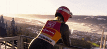 a woman wearing a vest that says hammer looks out over a snowy landscape
