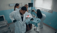 a man in a lab coat is standing next to a woman in a hospital bed and a sign that says sab fresca