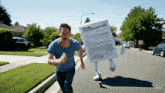 a man in a blue shirt is running down a street with a box on his back that looks like a form