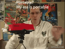 a man in a white shirt is standing in front of a red object that says portable on it