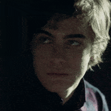 a close up of a young man 's face with his eyes closed
