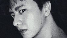 a close up of a man 's face with a black background in a black and white photo .