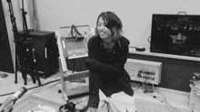 a black and white photo of a woman sitting in front of a microphone with a screen behind her that says nightmare