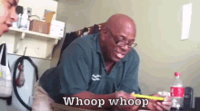 a man with glasses is sitting at a table with a bottle of coca cola in front of him and says whoop whoop