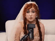 a woman with red hair is singing into a microphone .