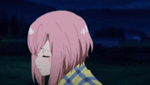 a girl with pink hair is wearing a plaid shirt and standing in a field at night .