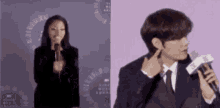 a man in a suit and tie is talking into a microphone next to a woman in a black dress .