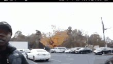 a man in a north face jacket stands in a parking lot