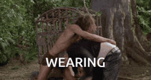 a shirtless man is being kicked by another shirtless man while wearing a towel around his waist .