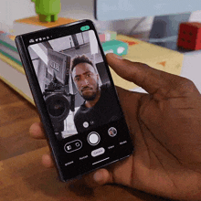 a person is taking a picture of a man on a phone with a camera icon