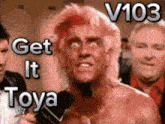 a shirtless man is talking into a microphone with the words get it toya behind him