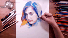 a person is drawing a woman 's face with colored pencils and markers on a table