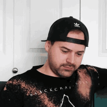 a man wearing a hat and a black shirt that says blackcraft cult