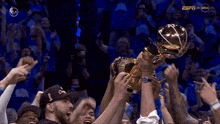 a group of basketball players holding a trophy with the espn logo on the bottom