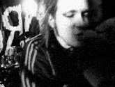 a black and white photo of a man singing into a microphone in a dark room .