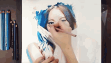 a person is drawing a woman with blue hair with prismacolor colored pencils in the background