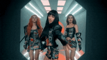three women are dancing in a dark room