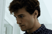 a close up of a man 's face with a plaid shirt