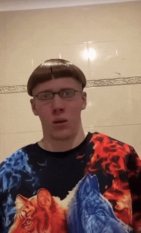 a man wearing glasses and a colorful shirt with fire and water animals on it