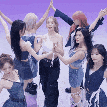 a group of women are standing in a circle with their hands in the air