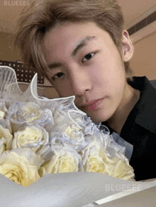 a close up of a person holding a bouquet of flowers with the word blueeee on the bottom