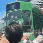 a green bus has the number 0 on the front