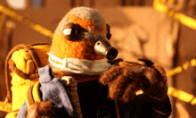 a stuffed animal wearing a mask holds a gun in its mouth