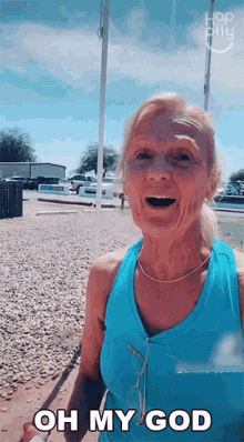 an elderly woman in a blue tank top is saying oh my god