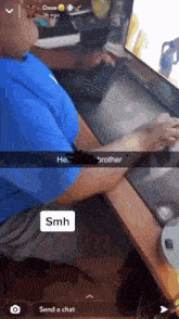 a man is sitting at a desk with a computer and a snapchat message that says " he brother smh "