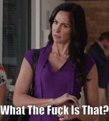 a woman in a purple dress is asking what the fuck is that