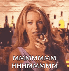 a woman is holding a glass of wine and talking on a cell phone
