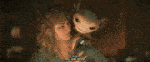 a woman is petting a small animal that looks like a dinosaur