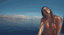 a woman in a bikini and sunglasses is reaching out towards the camera
