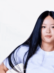 a woman with long black hair wearing a white t-shirt