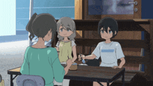 a girl wearing a shirt that says ' tokyo ' on it sits at a table