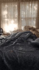 a bed in front of a window with blinds on