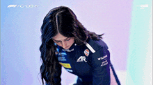 a woman in a williams racing suit is looking down