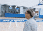 a man stands on a basketball court with the word detroit on it