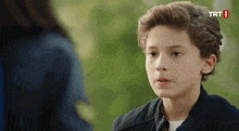 a young boy is talking to a woman with trt 1 written on the bottom