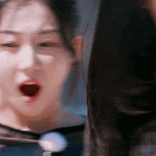 a close up of a woman 's face with a surprised look on her face