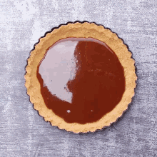 a pie crust is covered in a brown liquid