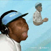 a man wearing headphones and a blue hat that says wolf