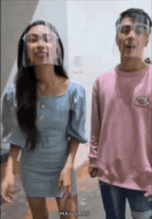 a woman wearing a face shield and a man wearing a pink shirt