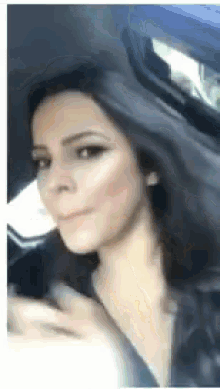 a woman is sitting in a car with her hair blowing in the wind