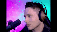a man wearing headphones and a microphone looks at the camera .